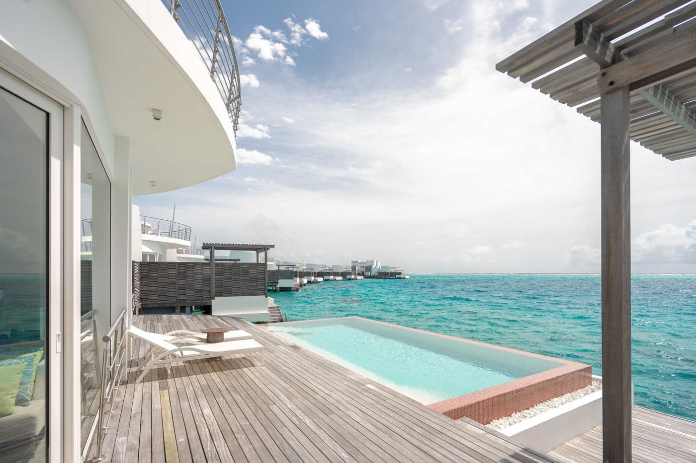 Modern white villa with infinity pool over turquoise water